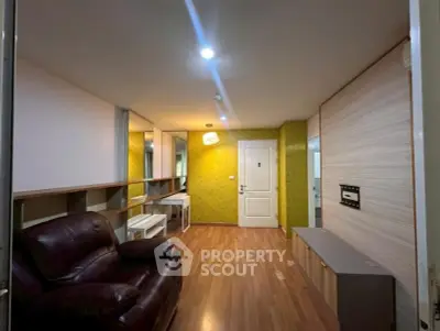 Modern living room with stylish decor and wooden flooring, featuring a comfortable leather sofa and sleek storage units.