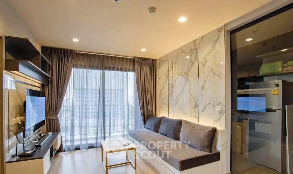 Modern living room with marble accent wall and large window in luxury apartment.