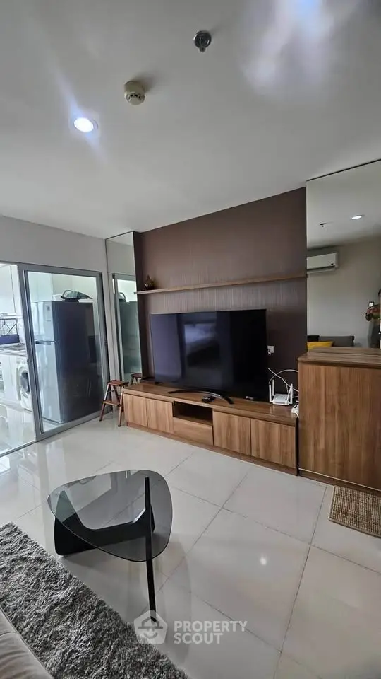 Modern living room with sleek furniture and large TV, perfect for relaxation and entertainment.