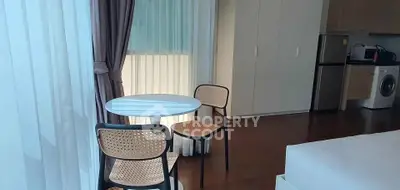 Modern studio apartment with dining area, kitchen, and washing machine.