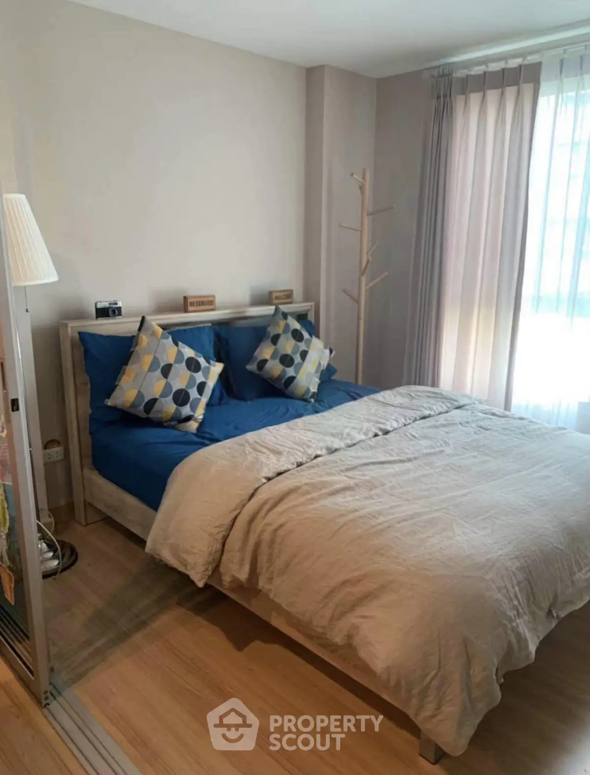 Cozy bedroom with stylish decor and natural light, perfect for relaxation and comfort.