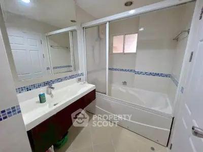 Modern bathroom with bathtub and sleek vanity in a stylish real estate property.