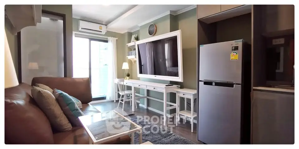 Modern living room with sleek furniture and stainless steel fridge in a stylish apartment.
