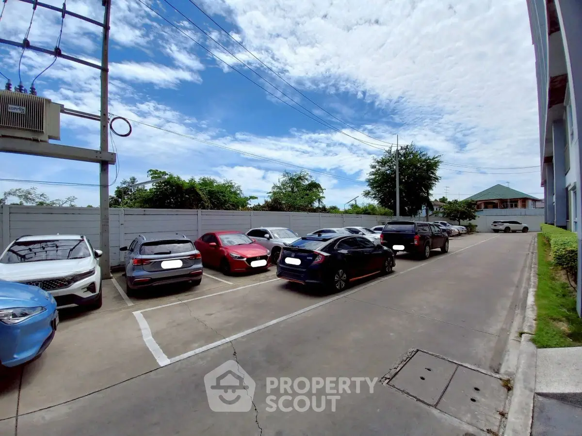 Spacious parking area with multiple cars under a clear blue sky, ideal for residential or commercial properties.