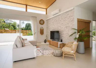 Spacious living room with modern decor and large windows offering natural light and garden view.