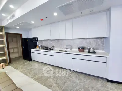 Modern kitchen with sleek cabinetry and marble backsplash in a spacious open layout.