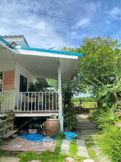 Charming countryside home with lush garden and inviting porch, perfect for tranquil living.