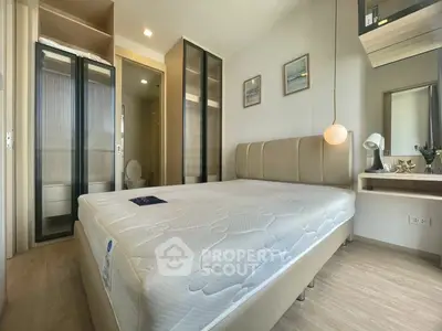 Modern bedroom with stylish decor and ample natural light, featuring a comfortable bed and sleek furnishings.