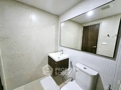 Modern bathroom with sleek fixtures and large mirror in a contemporary apartment.
