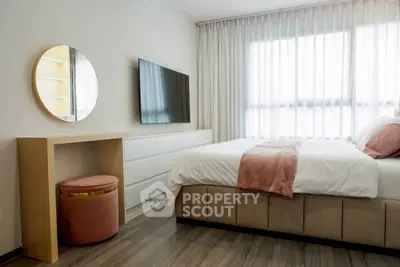 Modern bedroom with stylish decor, featuring a large bed, wall-mounted TV, and elegant curtains.