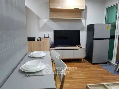 Modern living room with dining area and sleek appliances in a cozy apartment setting.