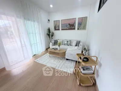 Stylish living room with cozy sofa, elegant decor, and natural light from large windows.
