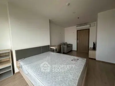 Spacious bedroom with modern furnishings and natural light in a contemporary apartment.