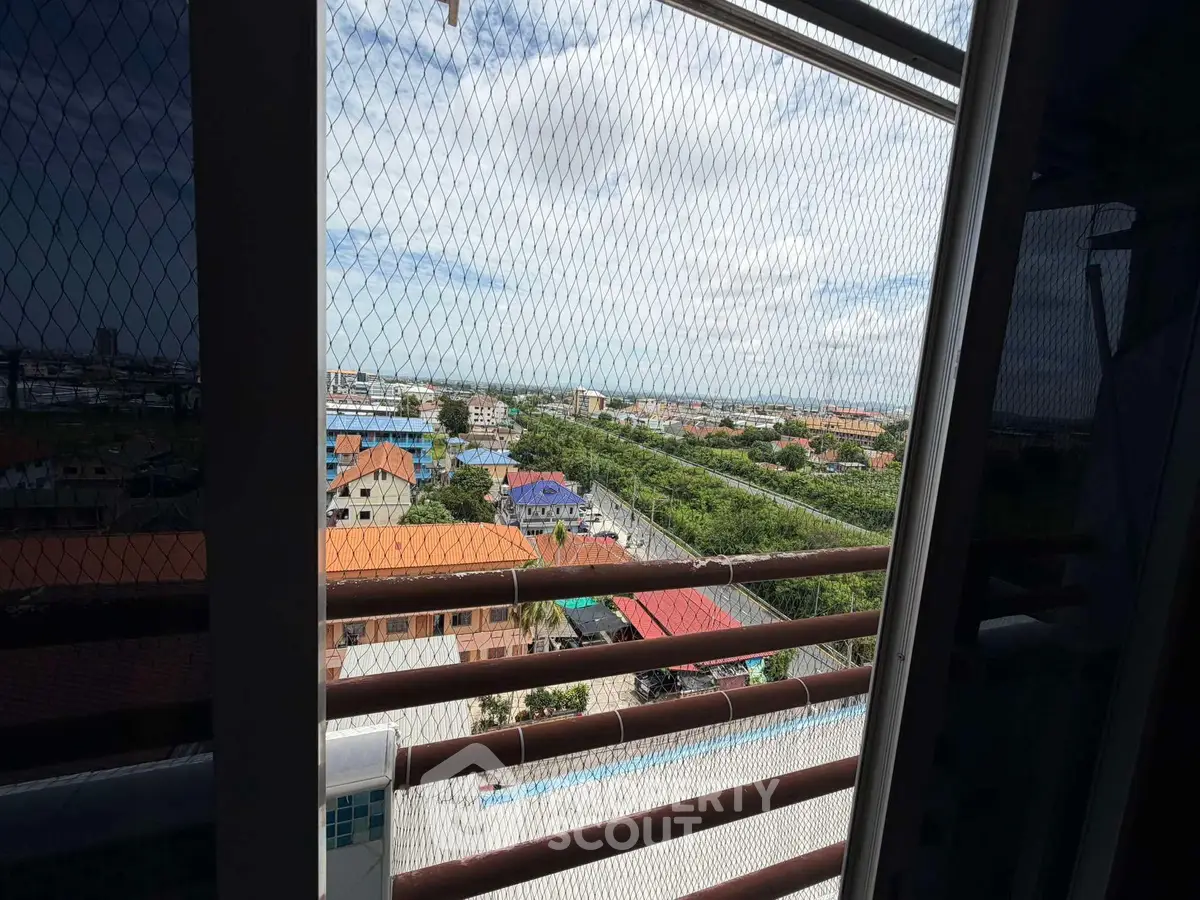 Stunning high-rise view showcasing lush greenery and urban landscape from a balcony.