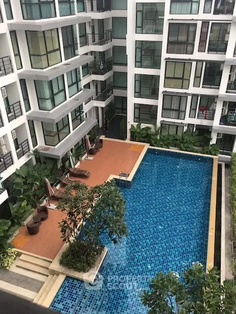 Modern apartment complex with a stunning pool view and lush greenery.