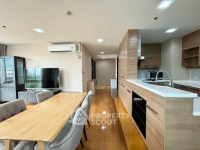 Spacious open-plan kitchen and dining area with modern wooden finishes and ample natural light.