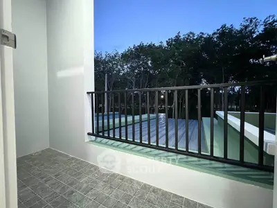Charming balcony with serene view of lush greenery, perfect for relaxation and outdoor enjoyment.