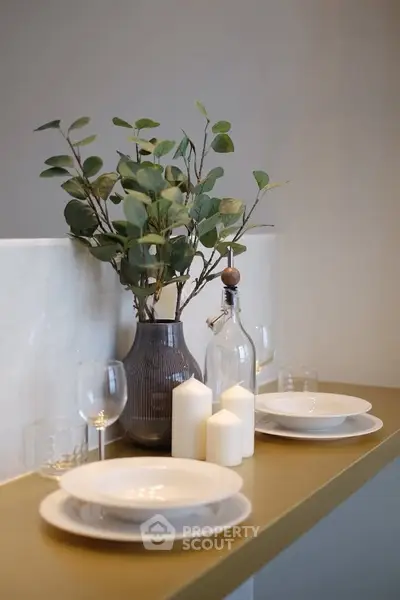 Elegant dining setup with modern decor and candles on a stylish countertop.