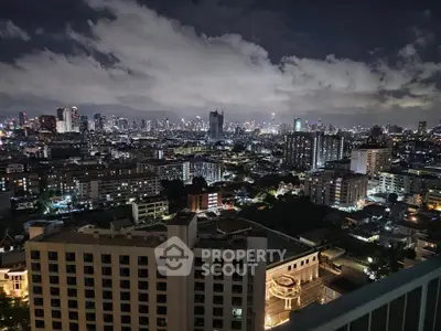 Stunning cityscape view from high-rise balcony at night, showcasing vibrant urban skyline.