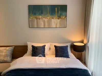 Cozy bedroom with modern decor and stylish artwork above the bed, perfect for relaxation.