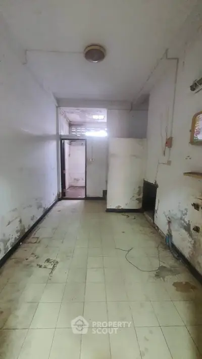 Spacious room with potential for renovation, featuring tiled flooring and high ceiling.