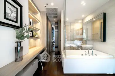 Modern bathroom with glass-enclosed bathtub and stylish study area in luxury apartment.
