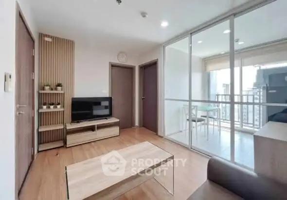 Modern living room with wooden flooring and balcony access in a stylish apartment.