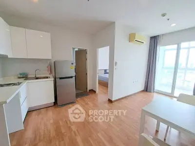 Modern open-plan kitchen and dining area with bright natural light and city view.