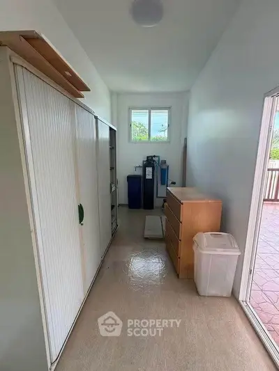 Spacious storage room with ample shelving and natural light, perfect for organizing household items.
