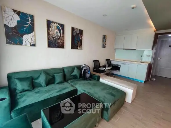 Modern living room with green velvet sofa and stylish decor in a contemporary apartment.