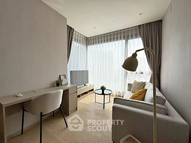 Modern living room with natural light, stylish furniture, and cozy ambiance in a high-rise apartment.