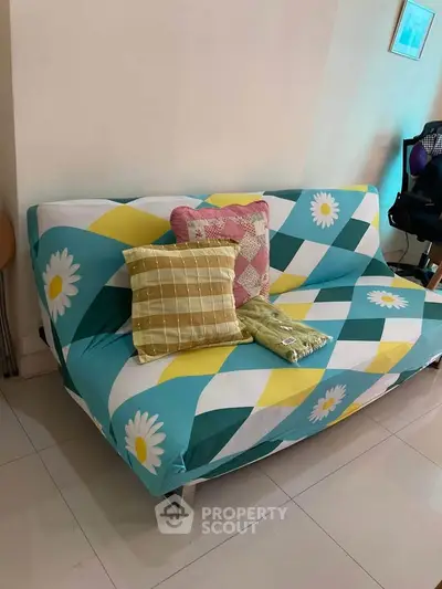 Cozy living room with colorful sofa and decorative pillows, perfect for relaxation.