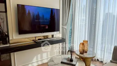 Stylish living room with modern decor and large TV, featuring floor-to-ceiling windows and elegant furnishings.