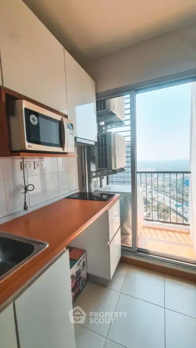 Modern kitchen with balcony view and sleek appliances