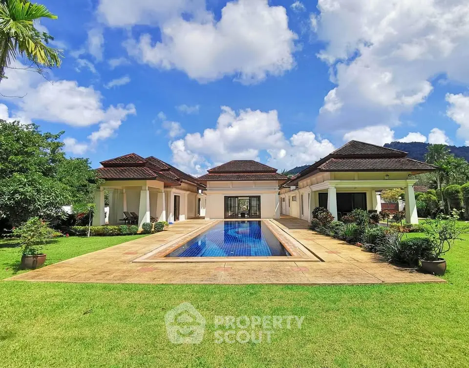 Luxurious villa with private pool and lush garden under a vibrant blue sky.