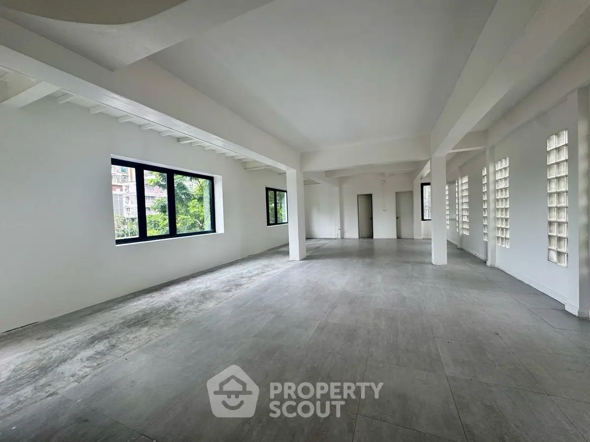 Spacious open-plan interior with large windows and modern design, ideal for versatile use.