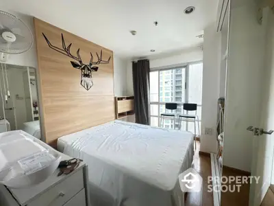 Modern bedroom with large window and stylish deer wall art in urban apartment