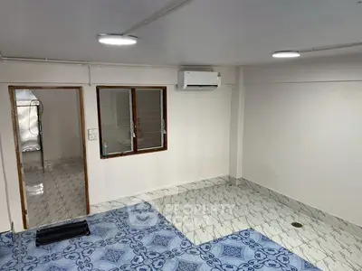 Spacious room with unique tiled flooring and air conditioning, ideal for versatile use.