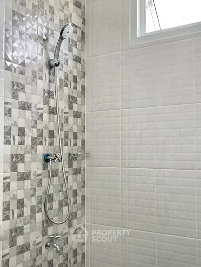 Modern bathroom shower with stylish tile design and chrome fixtures