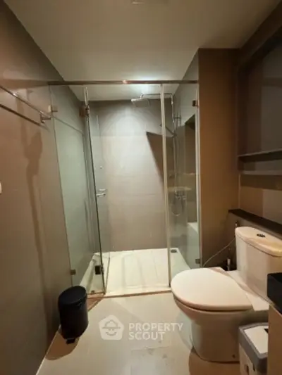 Modern bathroom with glass shower enclosure and sleek fixtures