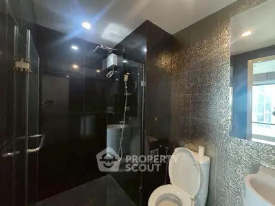 Luxurious modern bathroom with sleek black tiles and glass shower enclosure
