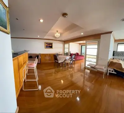 Spacious open-plan living room with wooden flooring and elegant decor.