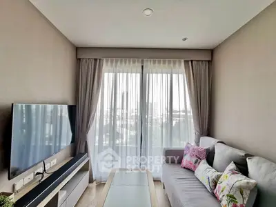 Modern living room with large window and stylish decor in a high-rise apartment.