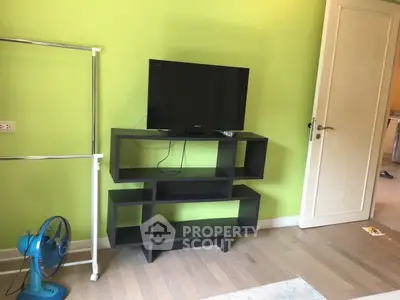 Modern living room with sleek TV stand and vibrant green walls