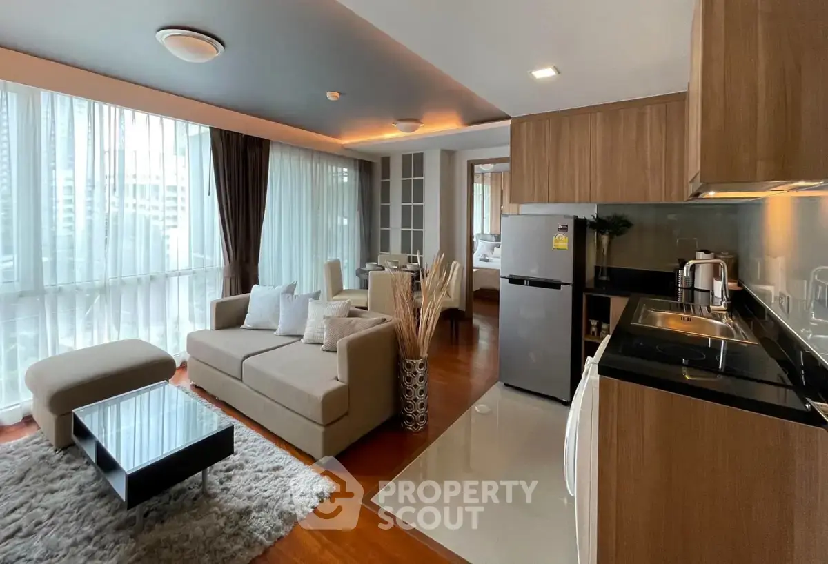 Modern open-layout living room and kitchen with large windows and stylish decor.