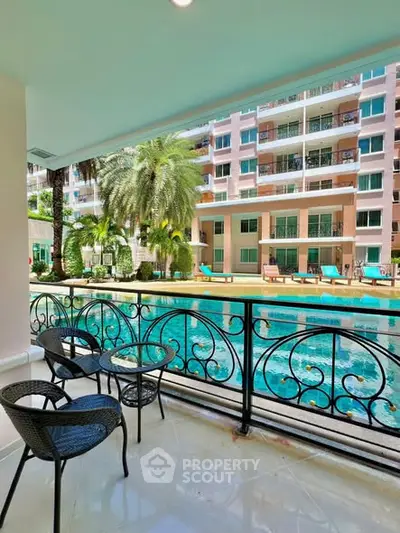 Luxurious balcony view overlooking a serene pool and modern apartment complex.