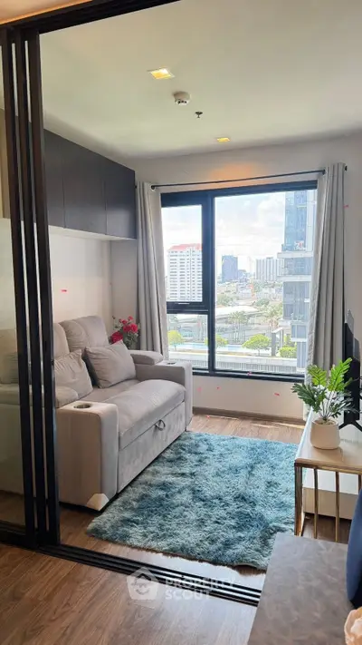 Modern living room with city view, cozy sofa, and stylish decor in high-rise apartment.