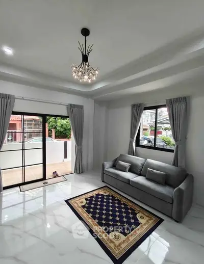 Spacious living room with elegant chandelier and modern decor in a bright, airy home.