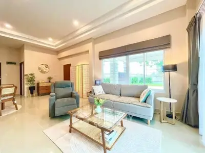 Spacious living room with modern decor and large window offering natural light.