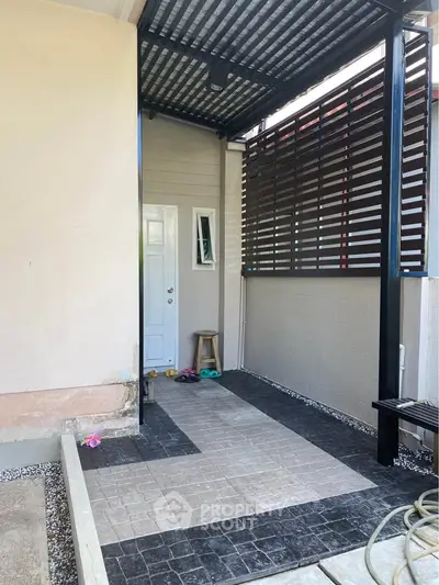 Modern house entrance with stylish covered walkway and sleek design.